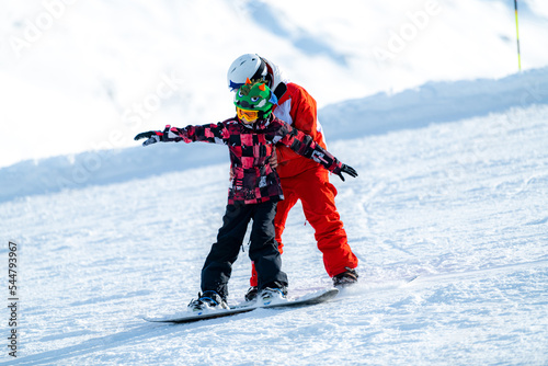Snowboard School. Boy with Instructor Learning Snowboarding.
