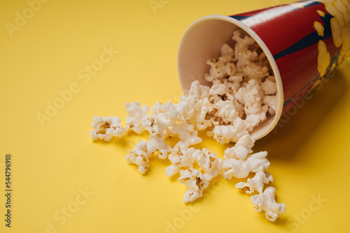 Popcorn snack in a cup on a yellow background. Close-up