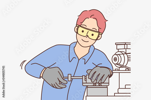 Male employee work on machine in workshop 