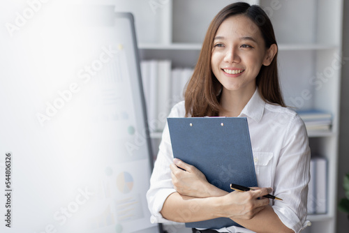 Young business Asian woman holding document file and stand in home office © David