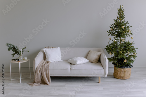 New Year's interior in the room. Festive Christmas tree. Cool stylish wall color. Minimalism in the house.