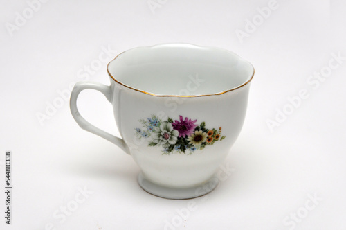 Empty ceramic cup with floral pattern on white background