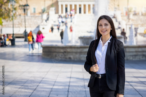 A Greek, professional business woman in corporate outfit standing on the Syntagma Square in Athens, Greece photo