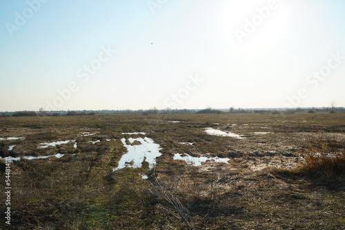 Canvas-taulu Puddles on a dirt road and a wild field during the autumn or spring thaw