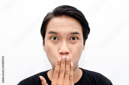 headshot of shocked, surprised, amazed young asian man in black tshirt isolated over white pointing with finger best for bussines advertismnet photo