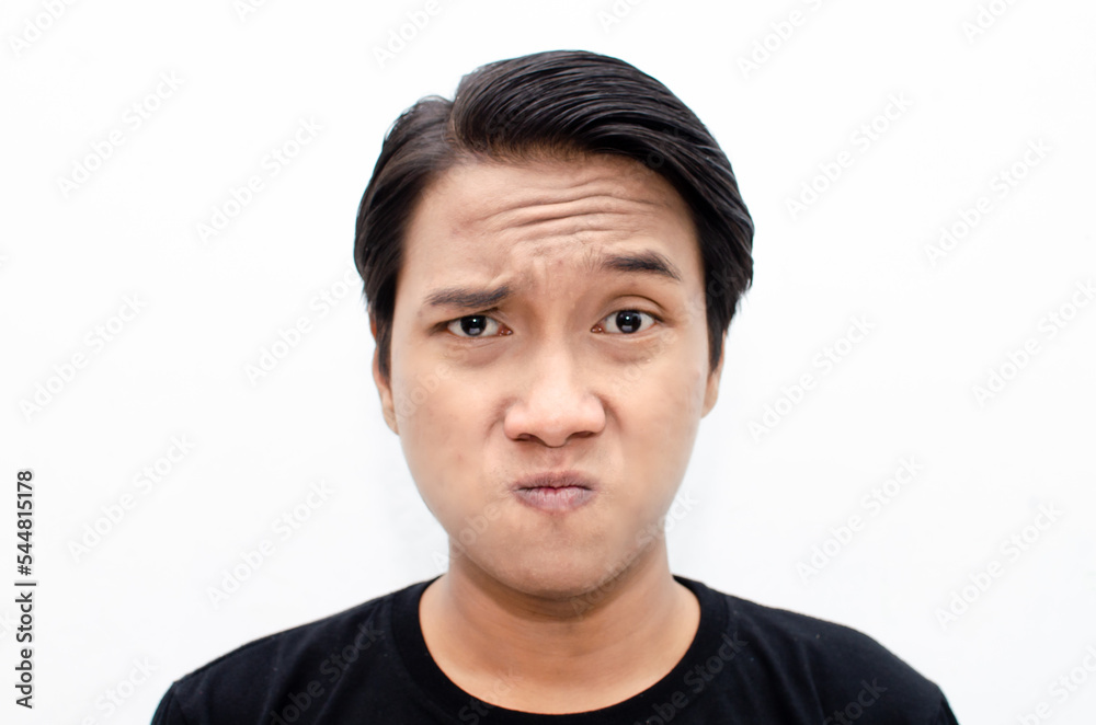 headshot of asian young man having doubt with unsure expression. man raising eye brow to intimidate. headshot of asian young man having doubt with unsure expression. man raising eye brow to intimidate.