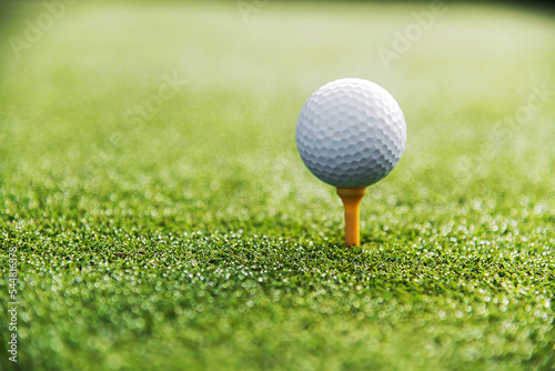 Golf ball on tee on green grass
