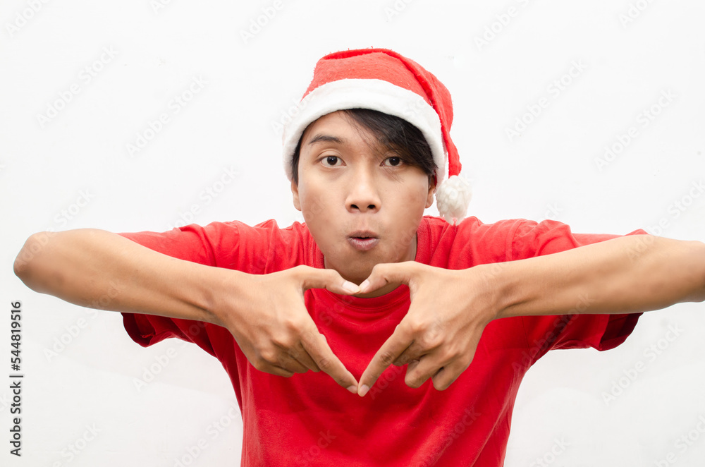 expressive happy confident young asian man in christmas santa theme clothes giving love hand gesture expressive happy confident young asian man in christmas santa theme clothes giving love hand gesture
