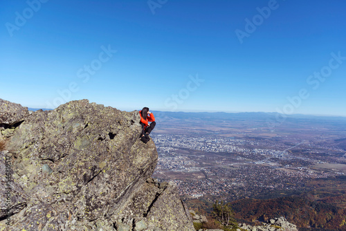 Woman sitting on a rocks high in the autumn mountain above the city of Sofia. Vitosha mountain, ,Bulgaria