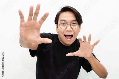 ecstactic attractive young asian man shocked happily opening mouth and lowering glasses. asian man with glasses feels shock with wow surprised expression.