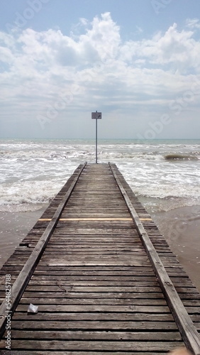 wooden jetty on covered by clouds beach