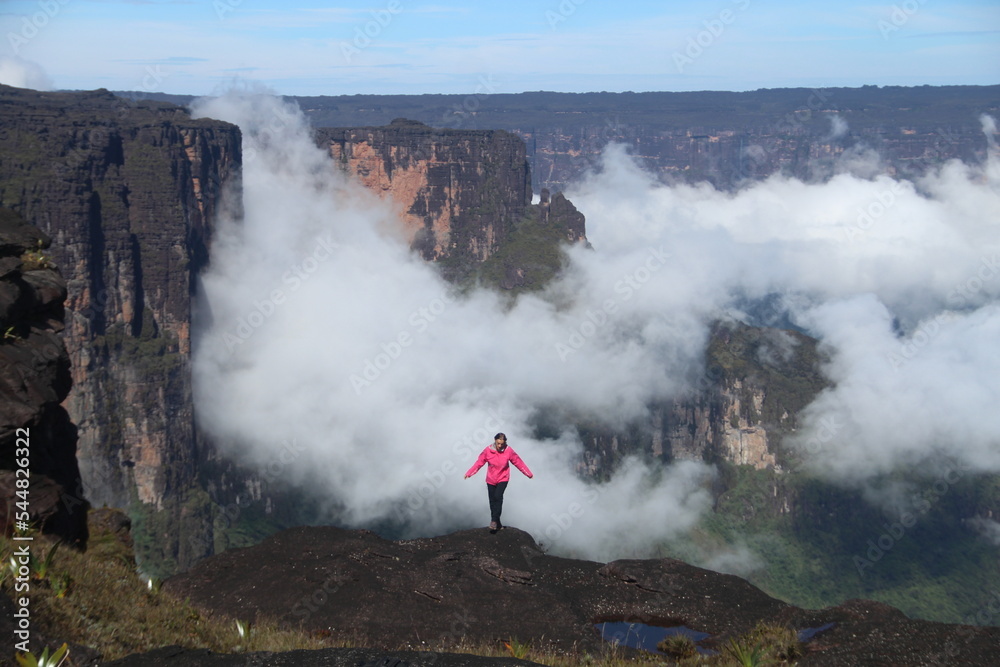 Fototapeta premium Mulher não identificada de casaco rosa no topo do Monte roraima