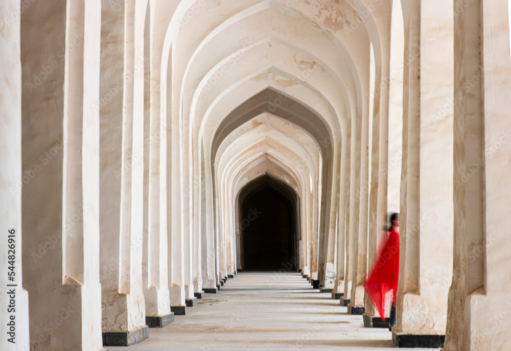 a woman in red passes by, bukhara, uzbekistan