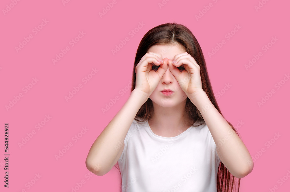 Serious girl making binoculars with hands Serious girl making binoculars with hands