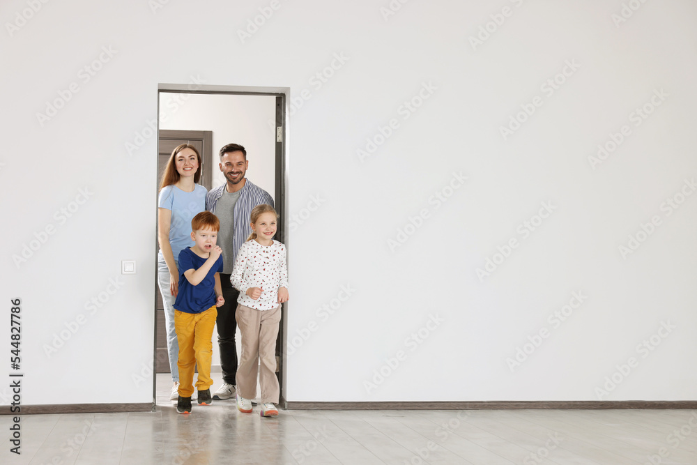 Happy family entering in their new apartment on moving day. Space for text Happy family entering in their new apartment on moving day. Space for text