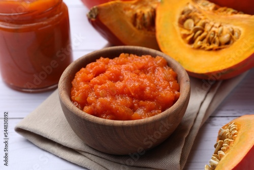 Delicious pumpkin jam and fresh pumpkin on white wooden table, closeup © New Africa