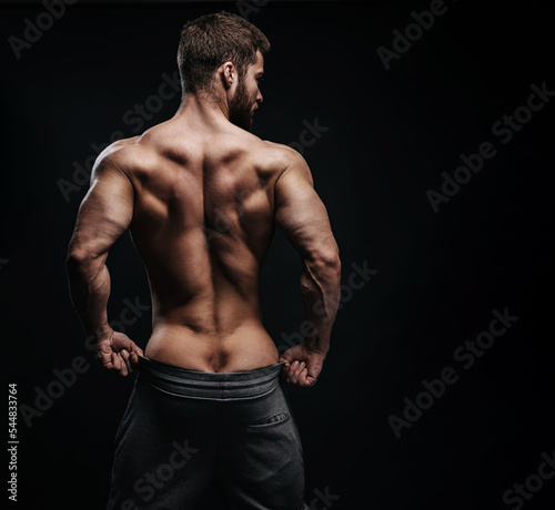 Photography Muscular male back at black background