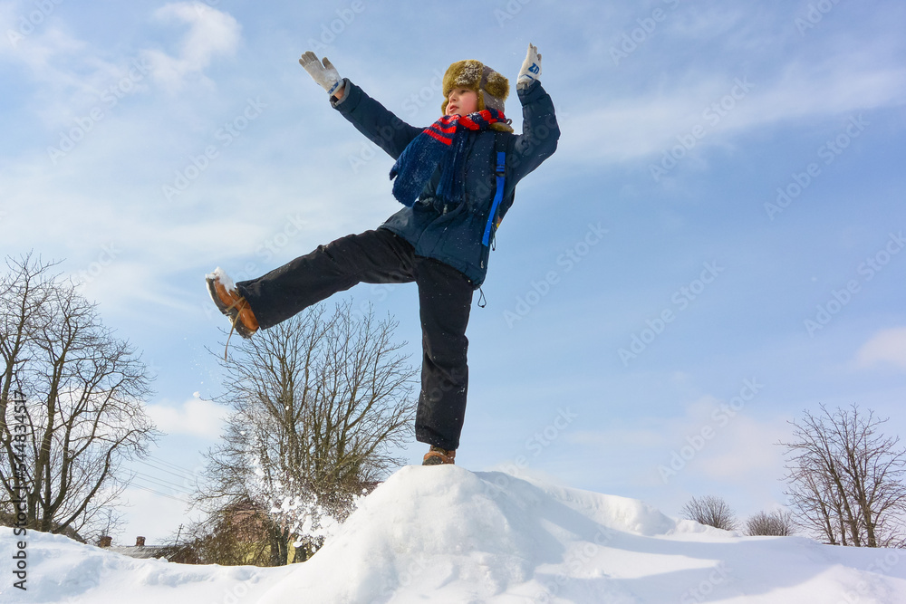 Happy boy jump outdoors. A boy plays outside in winter. Winter fun activity outdoor, winter vacation. Family time Happy boy jump outdoors. A boy plays outside in winter. Winter fun activity outdoor, winter vacation. Family time