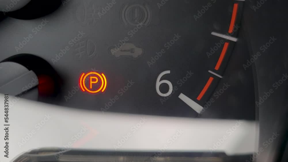 Car dashboard with red blinking icons of electric parking brake and car
