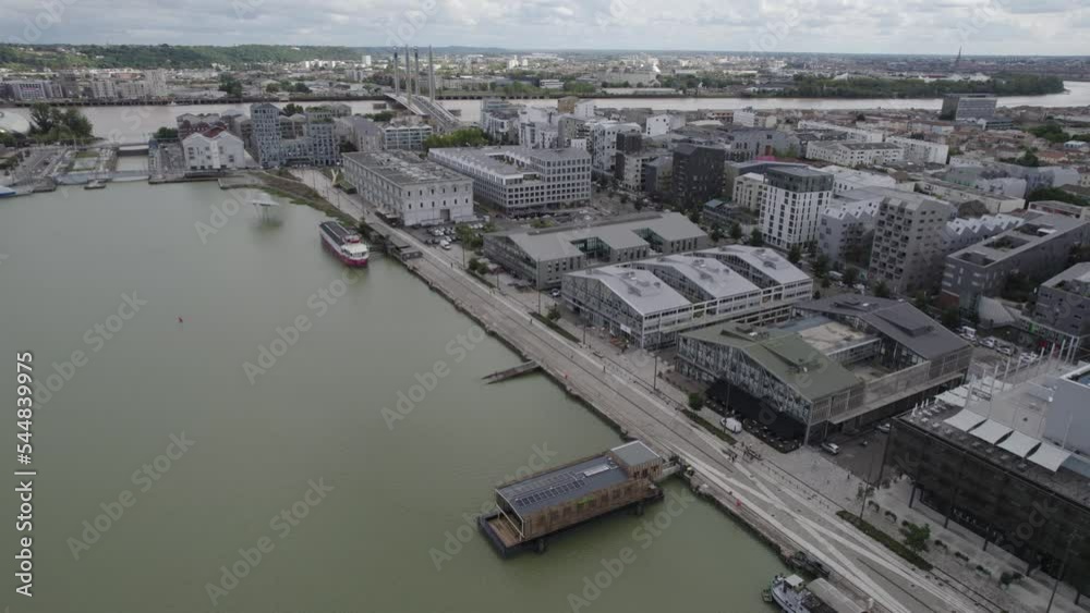 industrial warehouse area in Bordeaux France Bassins à Flots with a barge boat parked in the Garonne River, Aerial pan right reveal shot industrial warehouse area in Bordeaux France Bassins à Flots with a barge boat parked in the Garonne River, Aerial pan right reveal shot