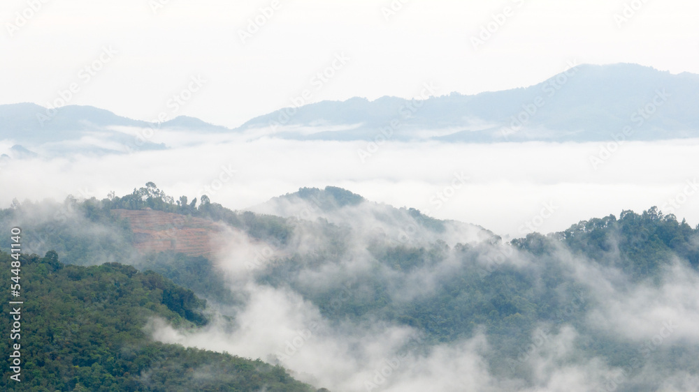Aerial view of clouds on beautiful mountains that covers the fertile tropical forests South of Thailand.