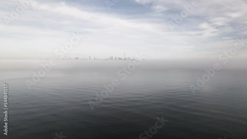 Toronto's Skyline in the distance as viewed from a drone flying over a foggy lake, Toronto, Canada captured by Anthony Saleh photo