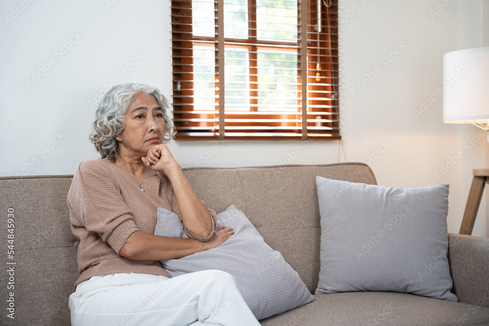 Elderly Asian woman sitting stressed on the sofa ,life insurance concept. Elderly Asian woman sitting stressed on the sofa ,life insurance concept.