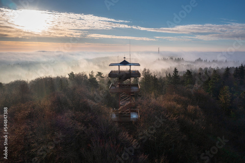 Beautiful landscape of Kashubia with a misty sunrise with a lookout tower in Wiezyca, Poland photo