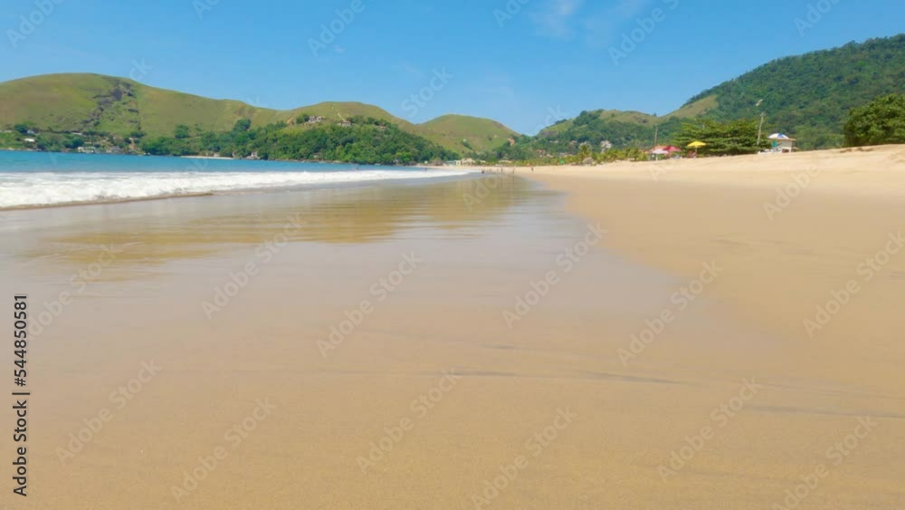 Beautiful and large beach of Garatucaia in Angra dos Reis. view of ocean wave breaking on the beach Beautiful and large beach of Garatucaia in Angra dos Reis. view of ocean wave breaking on the beach