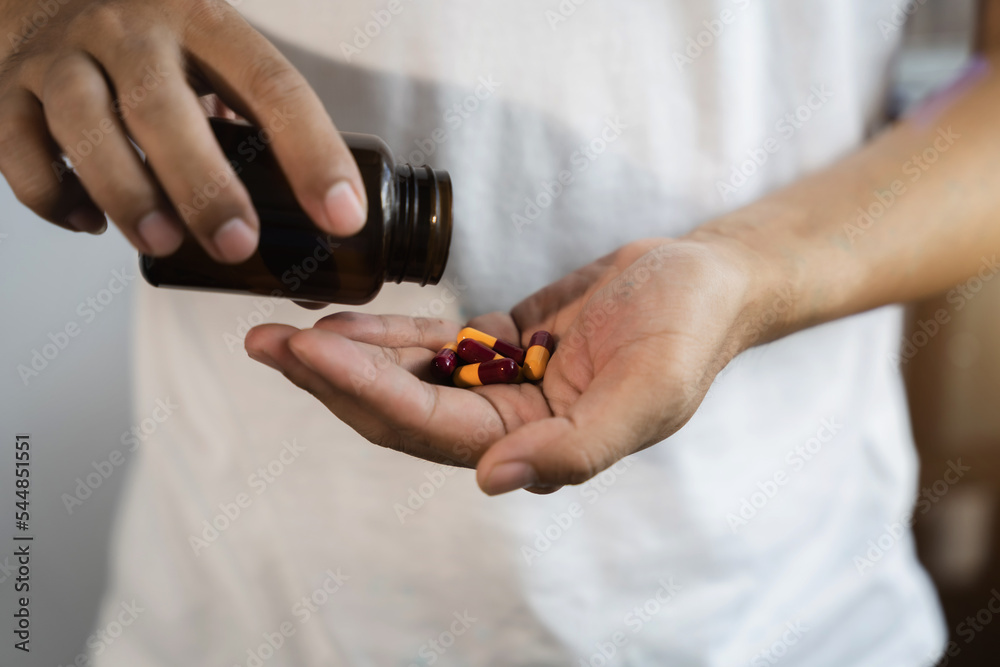Depressed man holding a glass of water, suffering from headaches. Depressed man holding a glass of water, suffering from headaches.