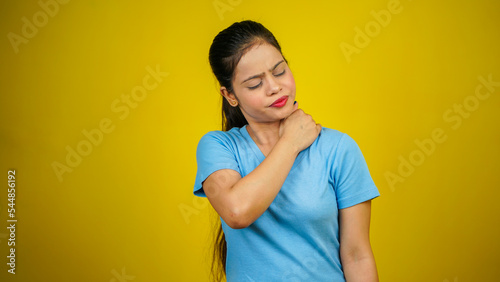 Young woman neck and shoulder pain and injury, Health care and medical concept, isolated yellow background