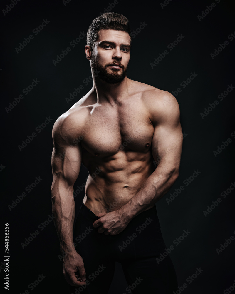 Athlete Sexy Athlete Man Or Bodybuilder Posing With Fit Torso Six Pack Six  Packs Abs Ab And Muscular Hands Biceps Triceps In Blue Sport Pants On  Beige Wall Fitness And Healthy Lifestyle