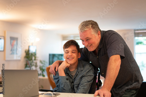 Father using laptop with son photo