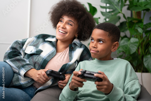 Mother and son playing video games at home photo