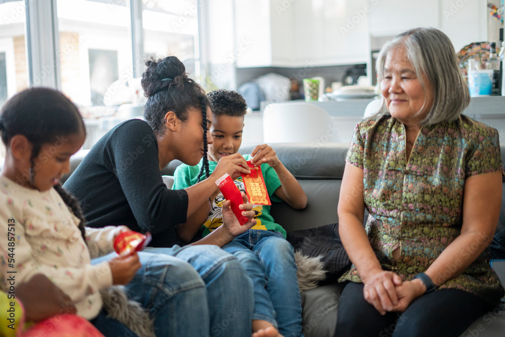 Family gathered in living room, sharing red envelopes Family gathered in living room, sharing red envelopes
