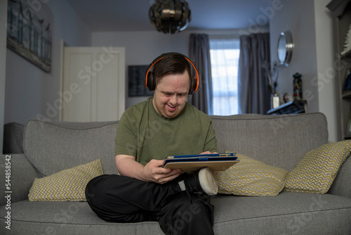 Man sitting on sofa and using digital tablet