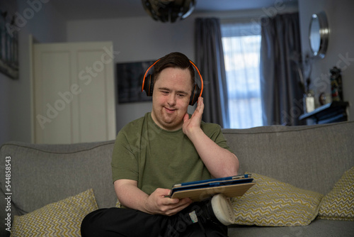 Man sitting on sofa and using digital tablet