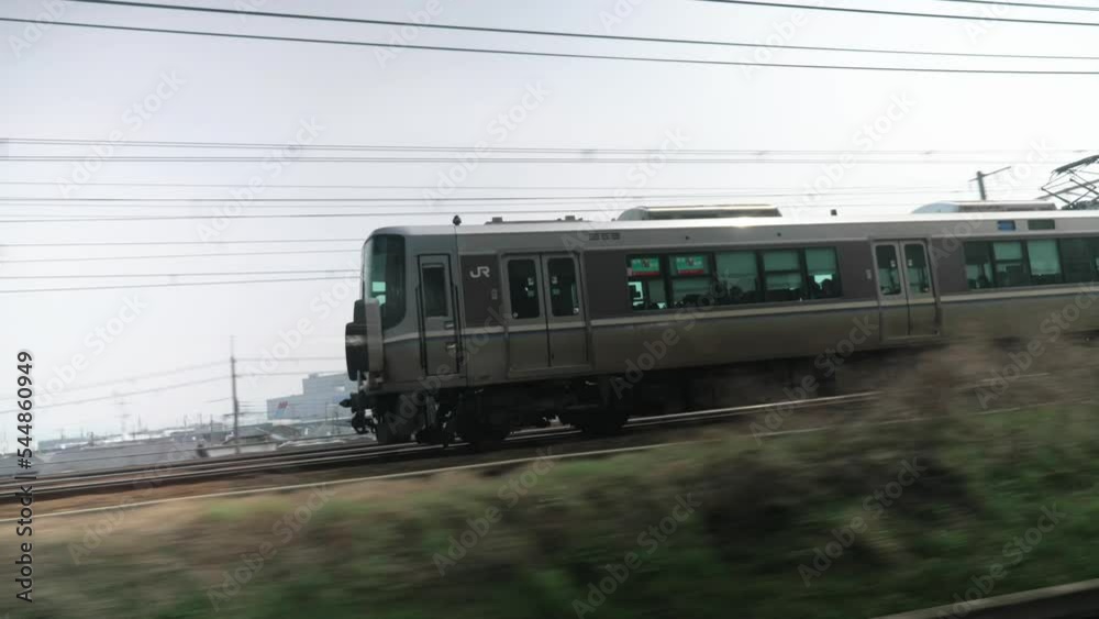 Chasing JR train from the window of another train through urban area, Japan Chasing JR train from the window of another train through urban area, Japan