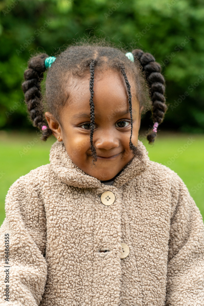 Portrait of smiling girl in coat standing in park in autumn Portrait of smiling girl in coat standing in park in autumn