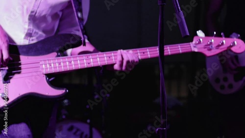 Guitarist playing a bass guitar on stage. Rock concert. Guitar player rocking the guitar.