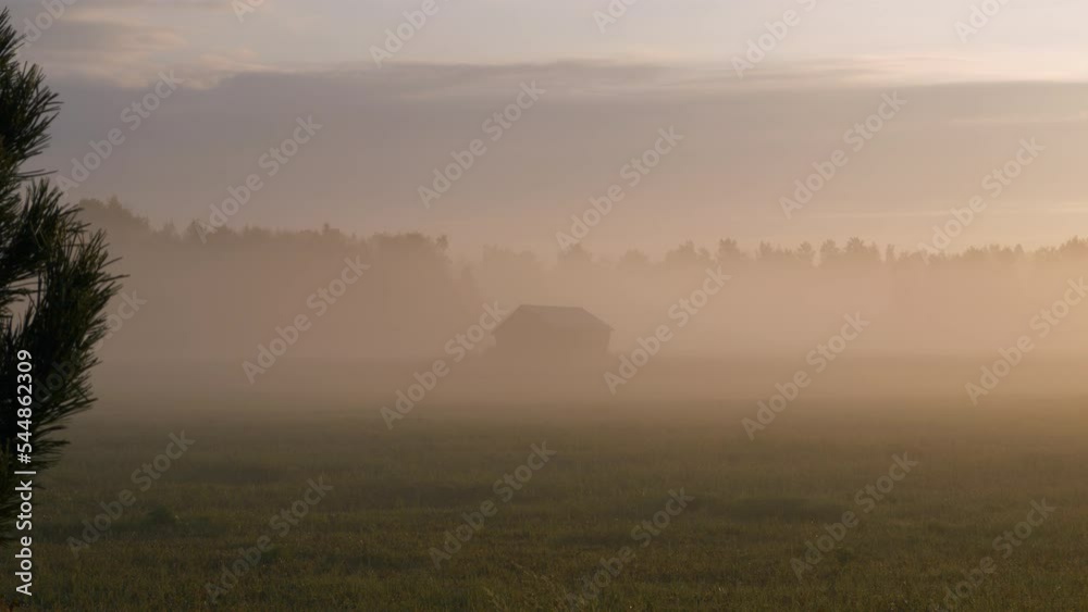 Silhouette of old barn hiding in foggy early morning, distance view Silhouette of old barn hiding in foggy early morning, distance view