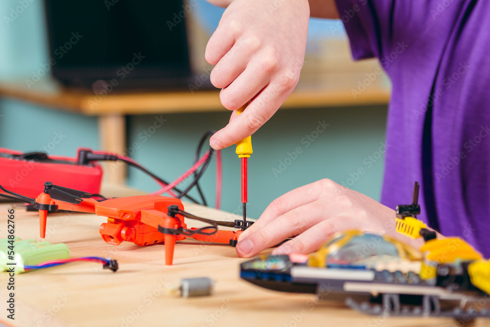The boy is fixing the drone. Primary technical education. The boy is fixing the drone. Primary technical education.