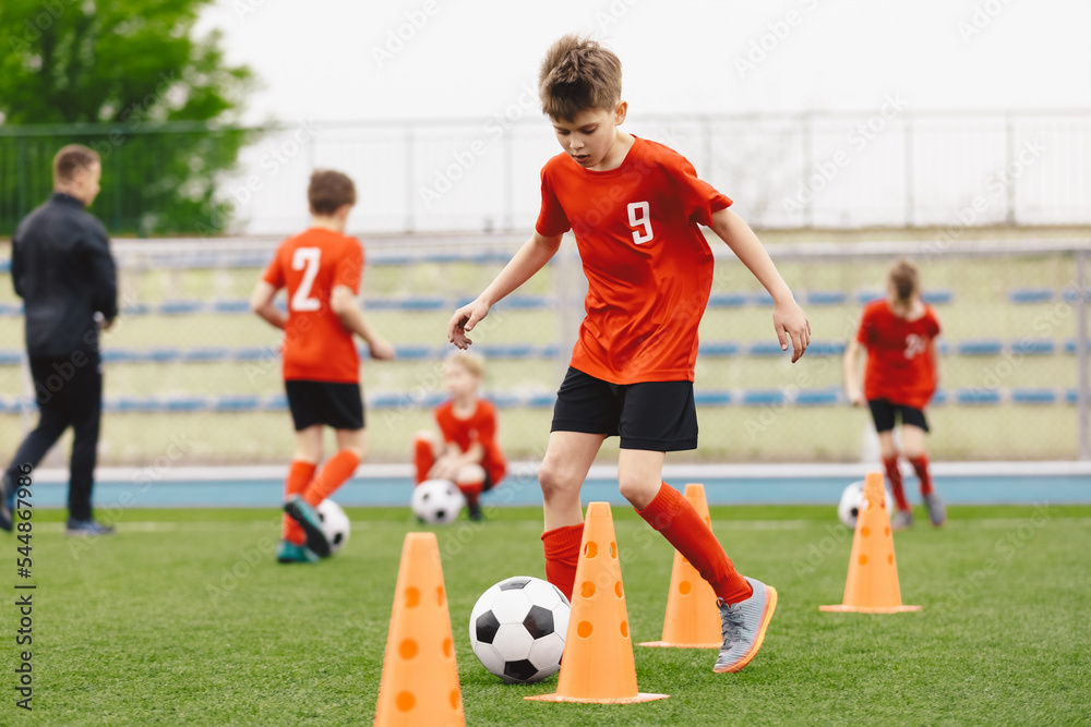 Young Boys on Football Practice Drill. Kids Running With Soccer Balls on Dribbling Training Trail Young Boys on Football Practice Drill. Kids Running With Soccer Balls on Dribbling Training Trail