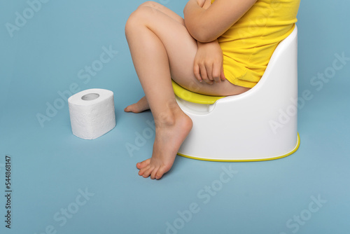 Obraz na plátně Baby on the potty, stomach pain. On a blue background.
