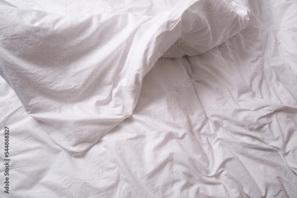 Top view of sheets and pillows. White linens. Bed texture
