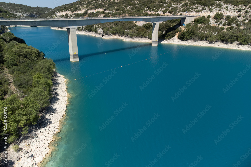Aerial view on blue lake Sainte-Croix-du-Verdon, road bridge and cliffs, tourists destination in France