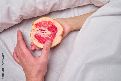 Fotografi Woman is holding a grapefruit in bed