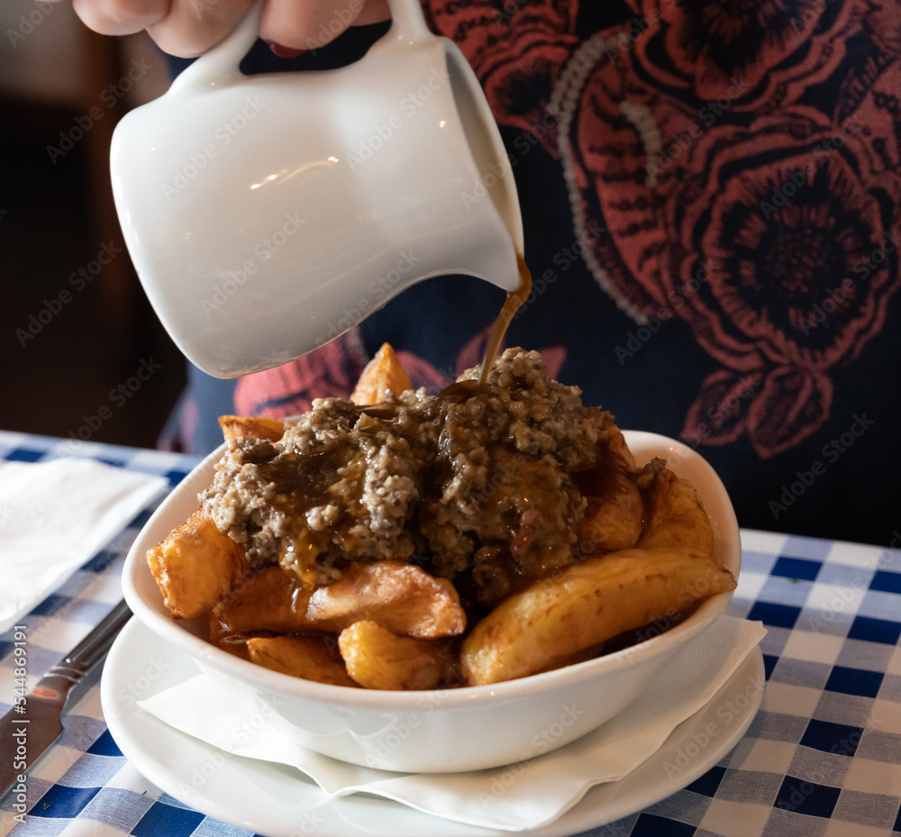 Foto de Scottish traditional snack food, hand cut potato chips topped