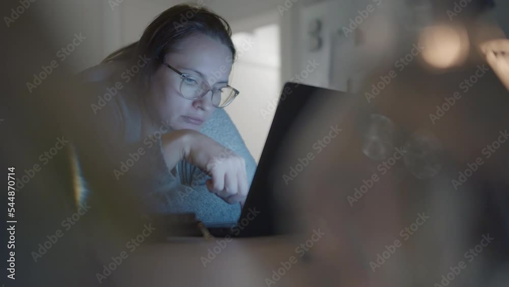 Woman wearing glasses and working online near laptop in domestic environment Woman wearing glasses and working online near laptop in domestic environment