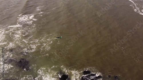 aerial view of a surfer entering the rough seas of the Atlantic Ocean at Punta del Este in Uruguay